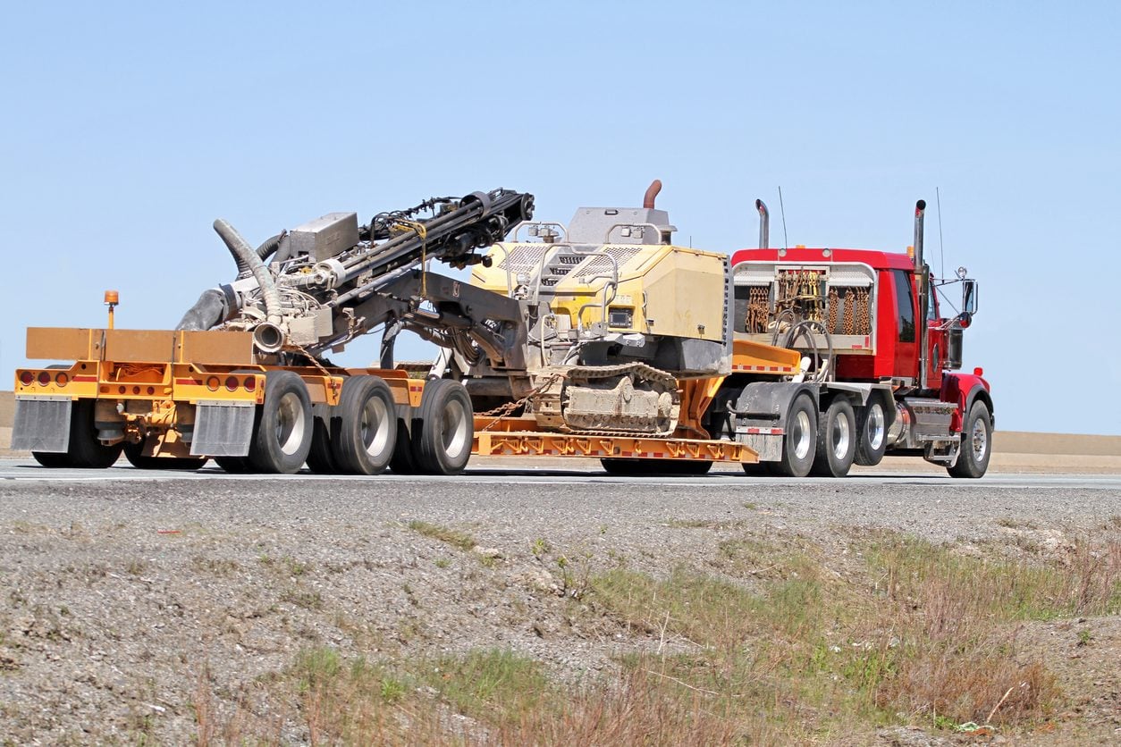 Flatbed truck transporting a portable drilling rig