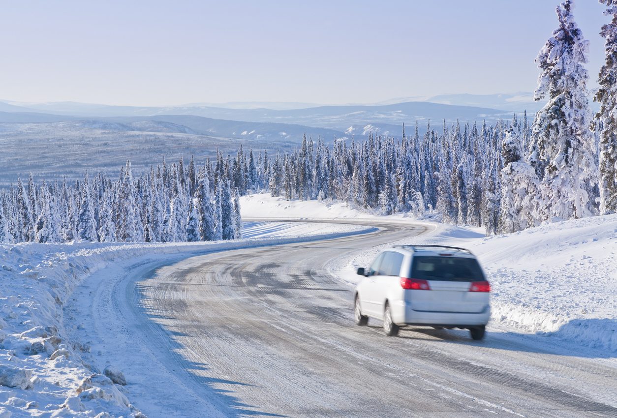 Vehicle on a snow covered highway through winter wilderness