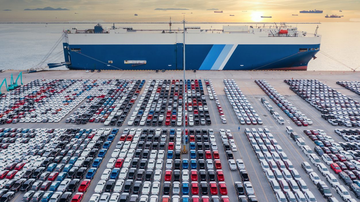 RoRo vehicle carrier loading rows of cars at a port