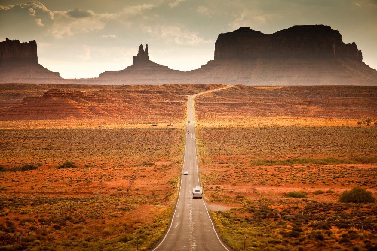 RV on a long desert highway through red rock country