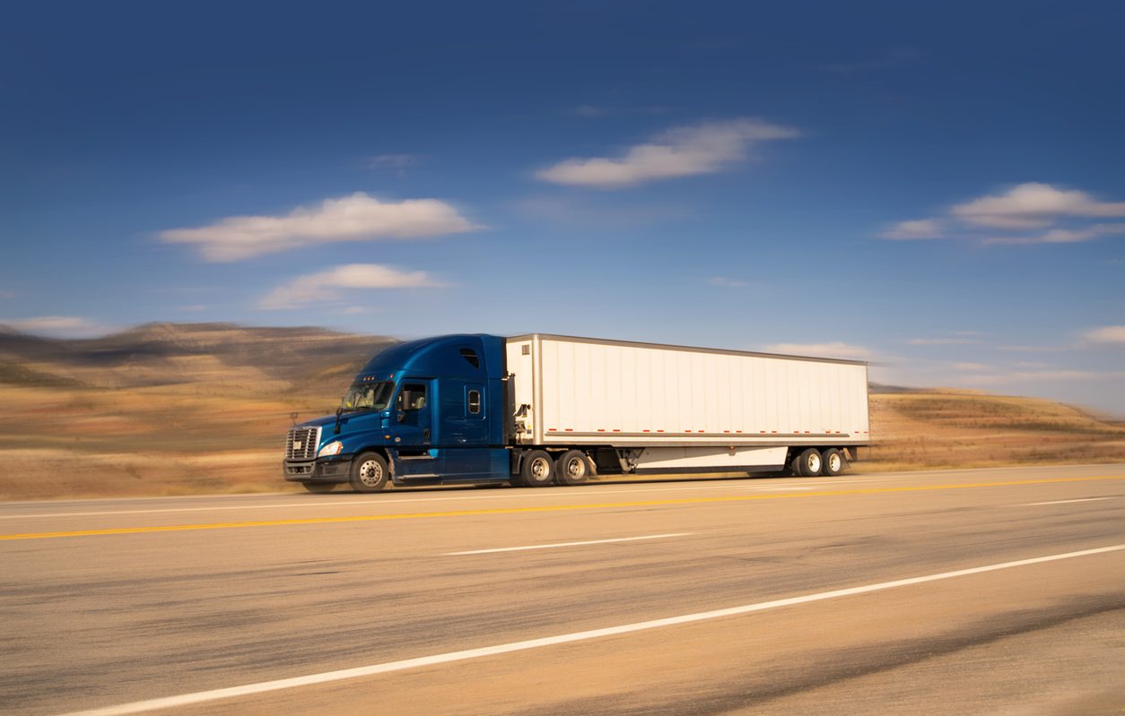 Semi truck running an open desert highway