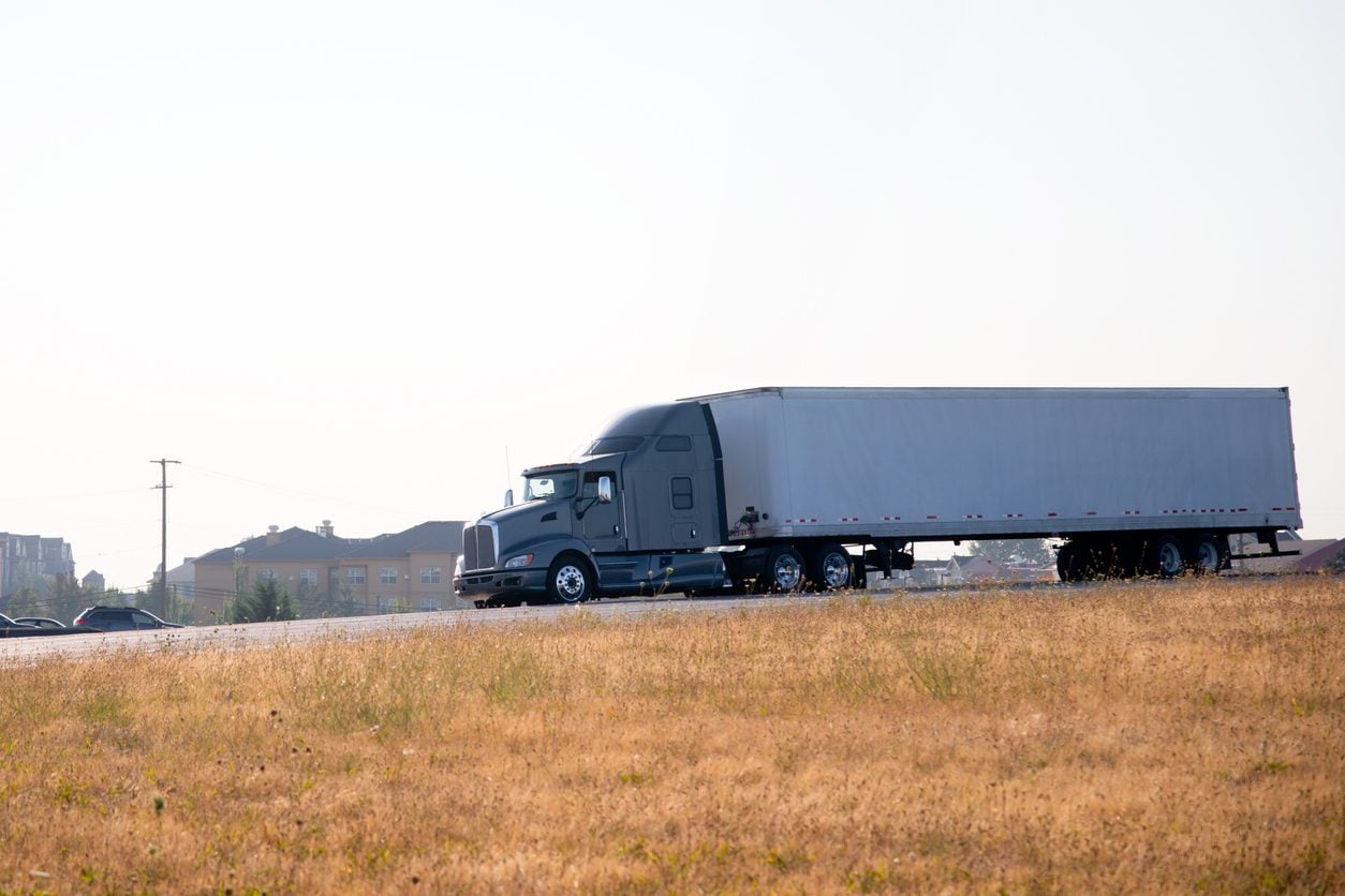 Side view of a semi truck and trailer on an open road
