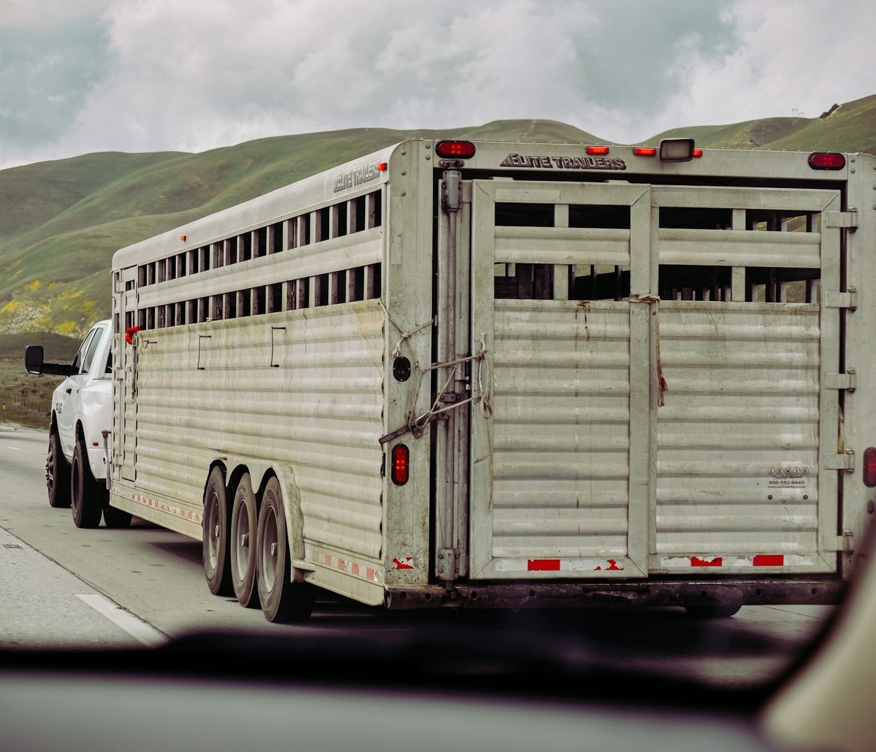 Gooseneck stock trailer being towed on a highway