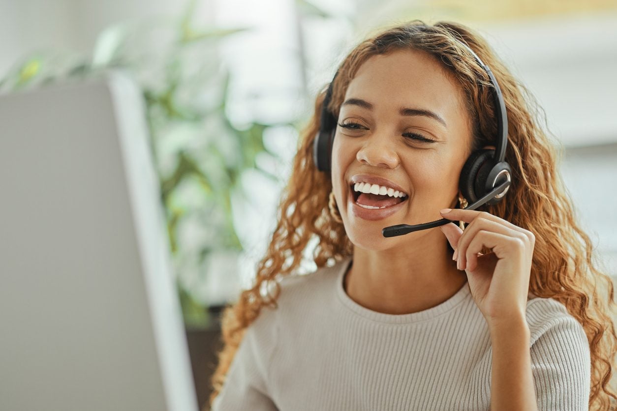 Support agent with a headset at a computer
