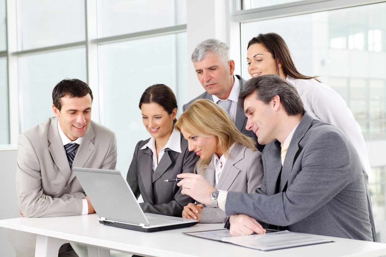 Colleagues reviewing information on a laptop together
