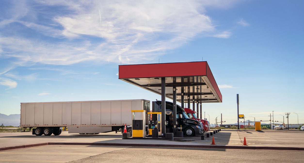 Tractor trailer parked under the canopy of a highway fuel station