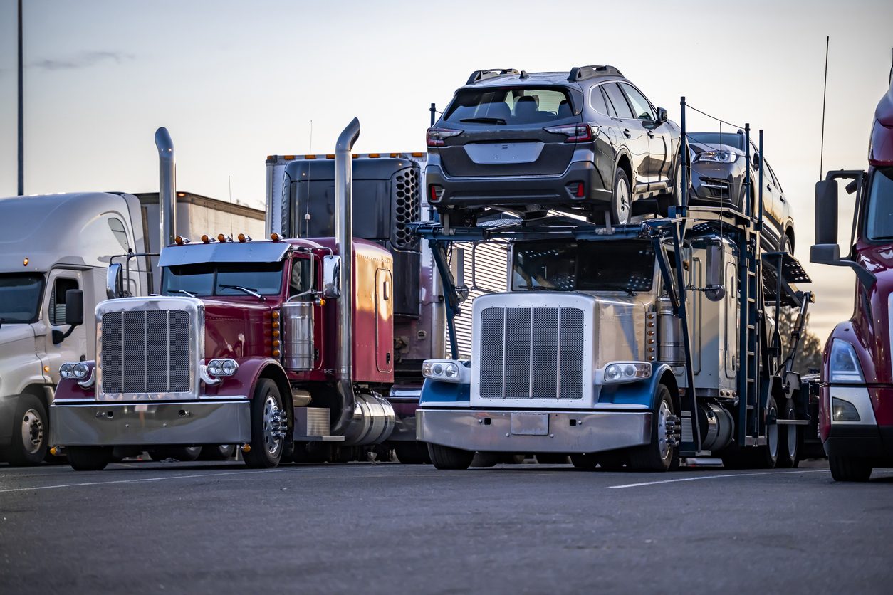 Car haulers and other rigs parked in a row at a truck stop