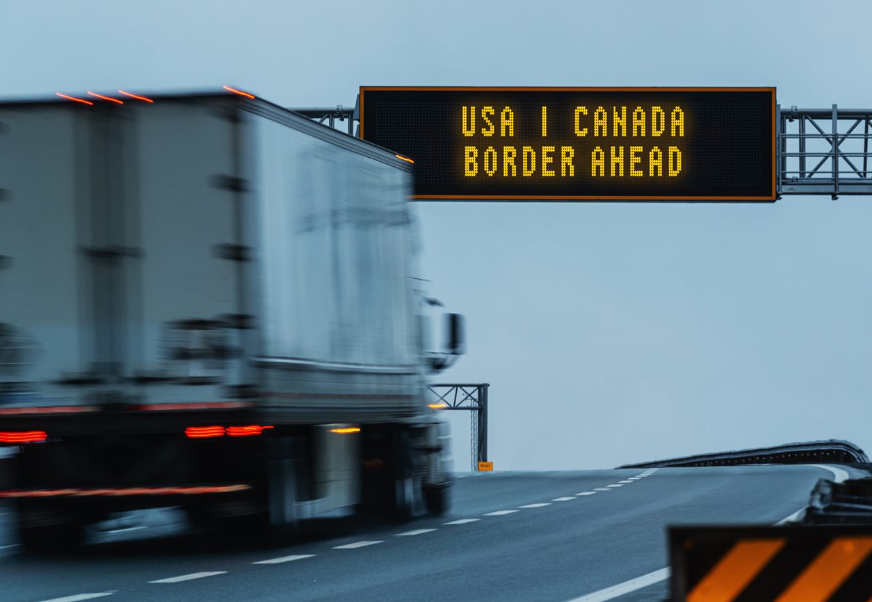 Highway sign reading USA Canada Border Ahead