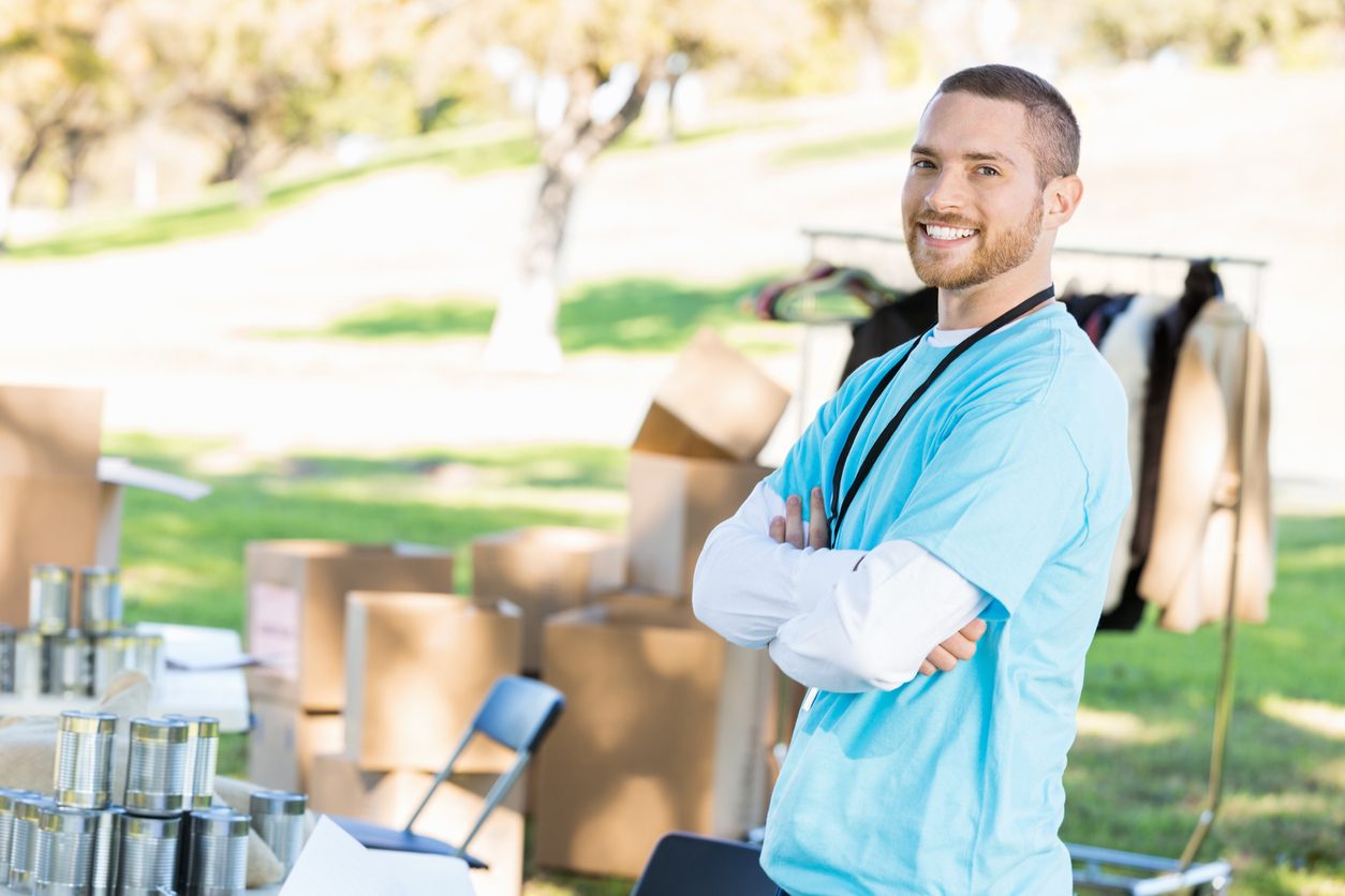 Volunteer beside donated goods at a collection point