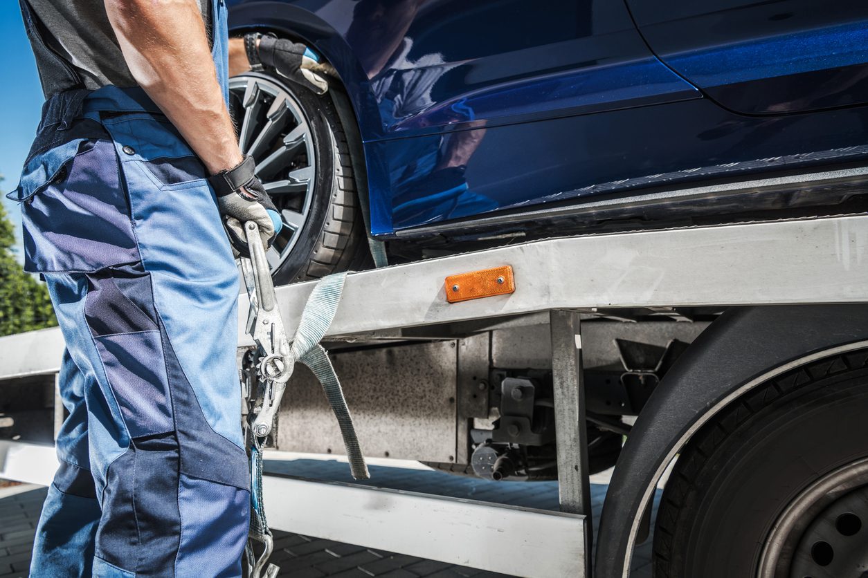Wheel strap secured over a tire on a transport deck