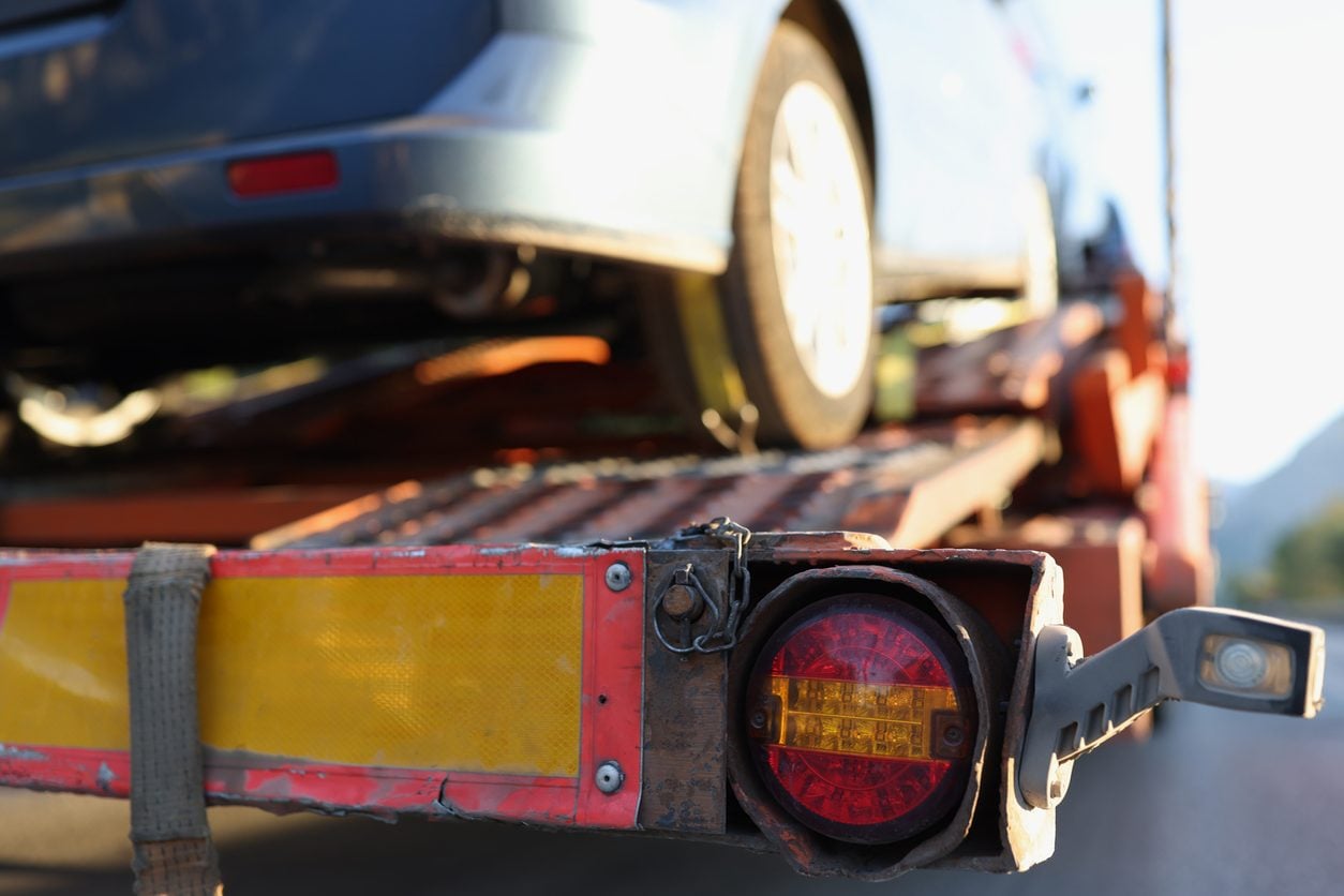 Non running car being winched onto a flatbed