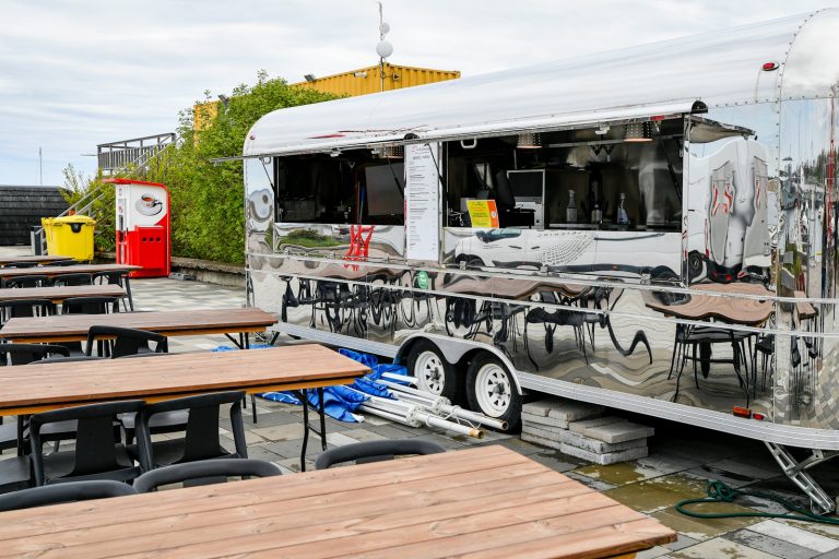 Polished chrome concession trailer with its serving windows open