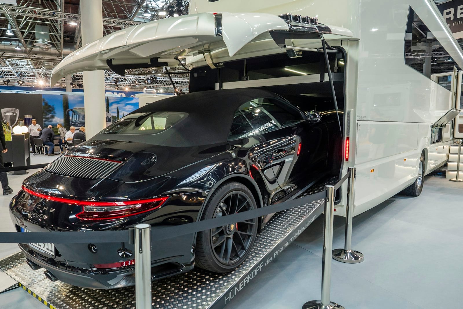 Black Porsche 911 cabriolet loaded inside the enclosed bay of a covered transporter
