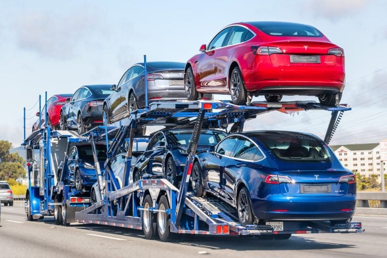 Open car carrier loaded with new vehicles on a US freeway