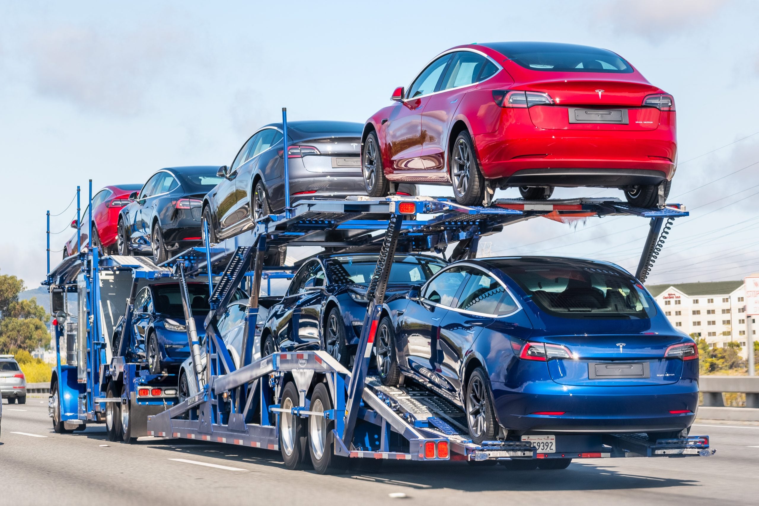 Open car carrier loaded with new vehicles on a US freeway