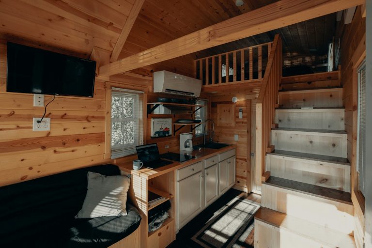 Tiny home interior with kitchen, loft, and staircase