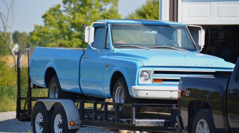 Classic pickup truck riding on a tandem axle utility trailer